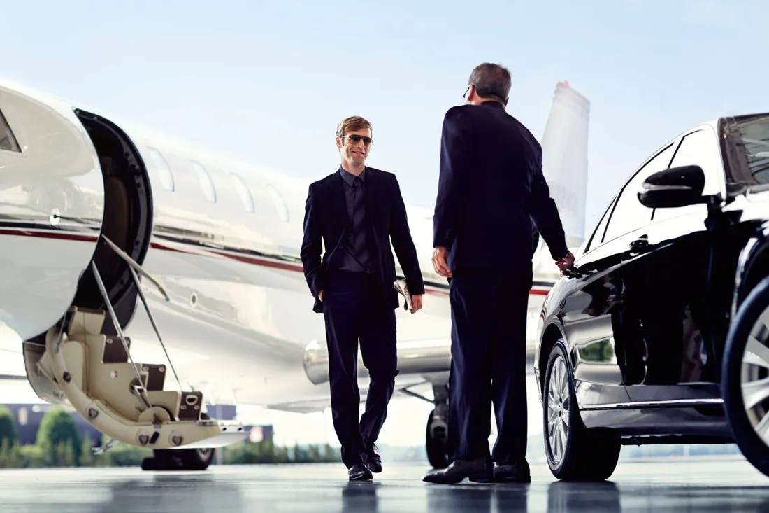 Chauffeurs meeting executives beside a private jet